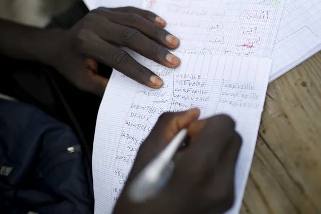Faris, from Sudan, learns French at “The New Jungle” camp in Calais, France, August 8, 2015. (Photo by Juan Medina/Reuters)