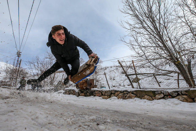 A boy sleds through snow as he enjoys the snow in Bahcesaray district called as planet nine because of roads blocked by snow in winter, in Van province of Turkey on January 22, 2020. (Photo by Ozkan Bilgin/Anadolu Agency via Getty Images)