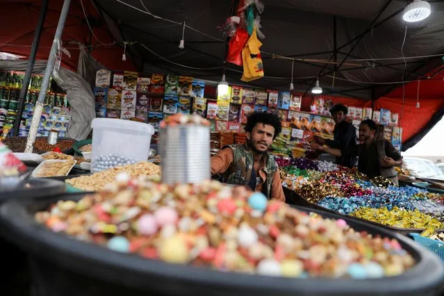 A vendor waits for customers at his sweets stall ahead of Eid al-Fitr, which marks the end of the holy month of Ramadan, in Sanaa, Yemen on April 30, 2022. (Photo by Khaled Abdullah/Reuters)