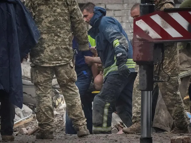 Rescuers extract a survivor from a residential building damaged by a Russian military strike in the town of Chasiv Yar, in Donetsk region, Ukraine, July 11, 2022. (Photo by Gleb Garanich/Reuters)