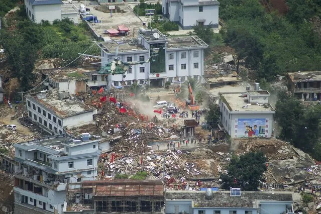 A helicopter flies above collapsed houses after a magnitude 6.3 earthquake hit Longtoushan town, Ludian county, Zhaotong, Yunnan province, August 4, 2014. The death toll from the earthquake that hit southwestern China on Sunday climbed to 398 people, state media reported on Monday. (Photo by Reuters/Stringer)