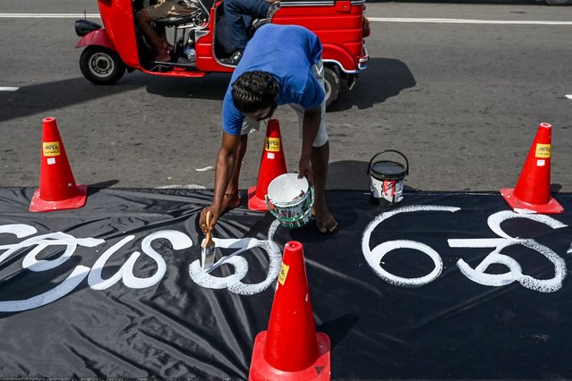 A demonstrator prepares to write slogans against interim Sri Lankan President Ranil Wickremesinghe onto a huge banner at the Galle face protest area near Presidential secretariat in Colombo on 17 July 2022. (Photo by Arun Sankar/AFP Photo)