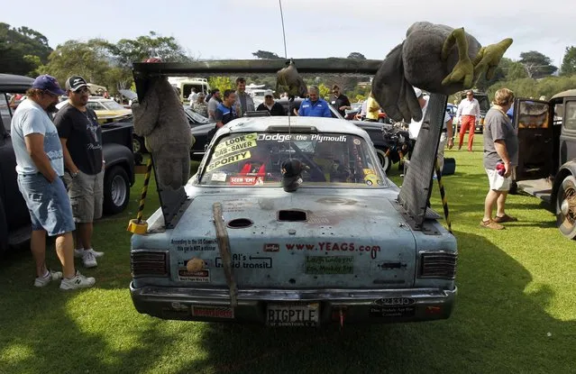 Guests view a 1966 Plymouth Belvedere II during the Concours d'Lemons car show in Seaside, California, August 16, 2014. (Photo by Michael Fiala/Reuters)