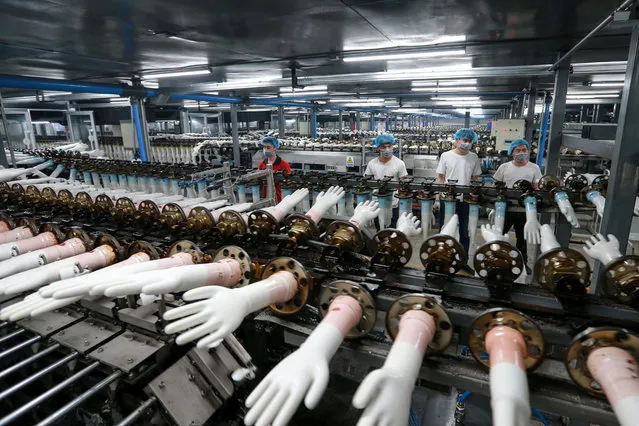 Workers produce medical gloves at a factory in Huaibei in China's eastern Anhui province on March 23, 2020. (Photo by AFP Photo/China Stringer Network)