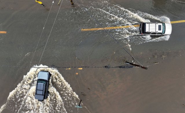 A drone view shows vehicles driving on flooded roads following heavy rains in Lytton, California on November 22, 2024. (Photo by Fred Greaves/Reuters)