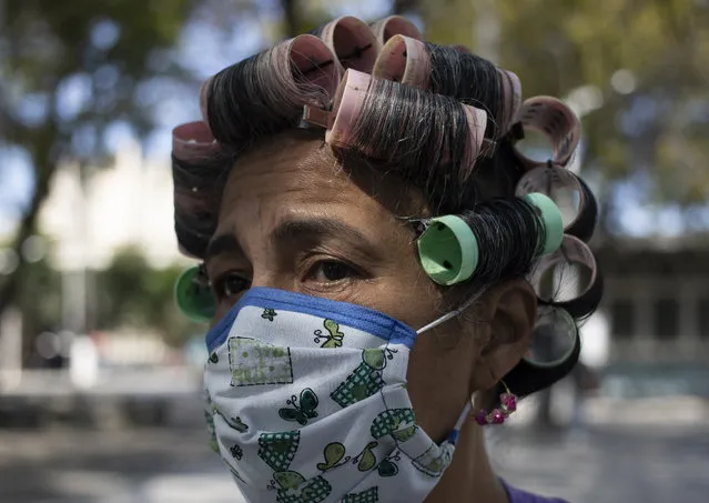 A woman wearing a home made mask as a precaution against the spread of the new coronavirus walks on a street in Caracas, Venezuela, Tuesday, March 17, 2020. President Nicolas Maduro, Monday night ordered the entire country to stay home and wear a mask under a quarantine in a bid to control the spread of the new coronavirus. According to the World Health Organization, most people recover in about two to six weeks from the virus, depending on the severity of the illness. (Photo by Ariana Cubillos/AP Photo)