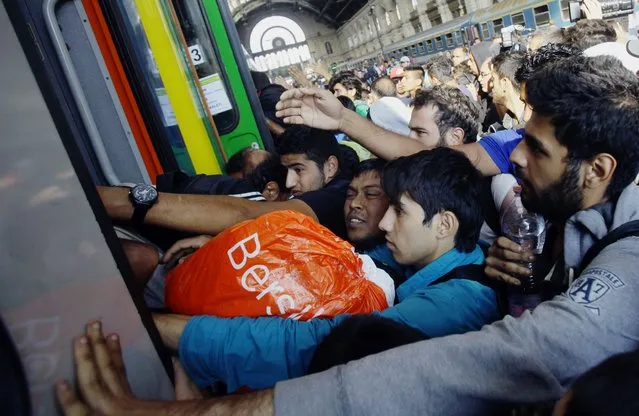 Migrants of several countries enter a local train with direction to the Hungarian-Austrian border at Keleti (East) railway station in Budapest on September 3, 2015. A train carrying between 200 and 300 migrants left Budapest's main international train station and headed toward the Austrian border, after authorities re-opened the station to migrants. (Photo by Peter Kohalmi/AFP Photo)