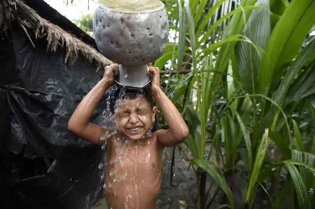 A young Rohingya refugee washes himself at the Jalpatoli refugee camp in the no-man's land area between Myanmar and Bangladesh, near Gumdhum village in Ukhia on September 16, 2017. According to the UN nearly 400,000 Rohingya have arrived in Bangladesh since August 25 after fleeing a military crackdown launched by Myanmar's military in response to attacks by Rohingya rebels. (Photo by Dominique Faget/AFP Photo)