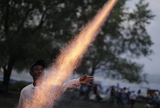 A man sets off fireworks in anticipation of a procession in honour of the Virgin of Sorrows in Dolores Apulo, El Salvador September 12, 2014. (Photo by Jose Cabezas/Reuters)