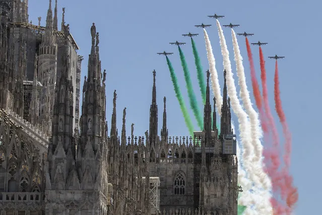 The Frecce Tricolori aerobatic squad of the Italian Air Force flies over Milan's Duomo cathedral, northern Italy, Monday, May 25, 2020 on the occasion of the 74th anniversary of the founding of the Italian Republic on June 2, 1946. This year the acrobatic squad will fly over several Italian cities to bring a message of unity and solidarity during the coronavirus pandemic. (Photo by Luca Bruno/AP Photo)