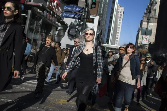 In this September 17, 2014 photo, commuters walk along Manhattan's 34th Street, in New York. (Photo by John Minchillo/AP Photo)