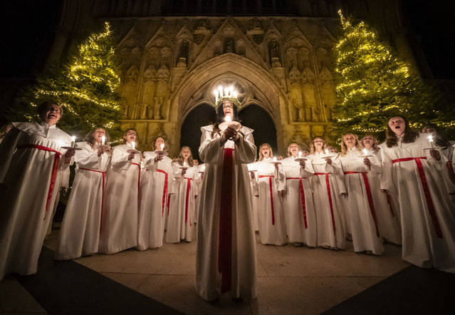 Alida Freding wears a crown of candles symbolising St Lucy as she leads the celebration of Sankta Lucia: Festival of Light at York Minster, in York, England, Monday, December 16, 2024. (Photo by Danny Lawson/PA Wire via AP Photo)