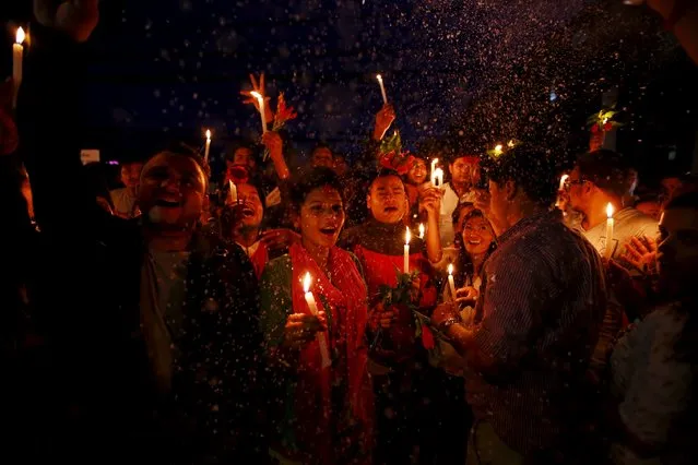 Nepalese students celebrate as they take part in the candlelight vigil welcoming the new constitution in Kathmandu, Nepal September 17, 2015. Nepal, which emerged from civil war in 2006, is in the final stages of preparing a new constitution that would carve the country of 28 million people into seven federal provinces. (Photo by Navesh Chitrakar/Reuters)