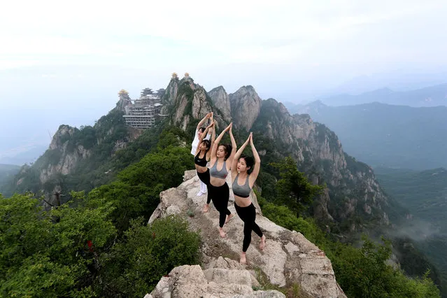 People practice yoga on a cliff at an attitude of over 2,000 meters at Laojunshan mountain to welcome upcoming International Yoga Day on June 20, 2020 in Luoyang, Henan Province of China. (Photo by VCG/VCG via Getty Images)