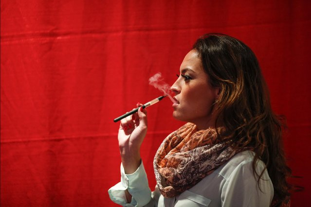 A woman uses a electronic vaporizers with cannabidiol (CBD)-rich hemp oil while attending the International Cannabis Association Convention in New York, October 12, 2014. (Photo by Eduardo Munoz/Reuters)