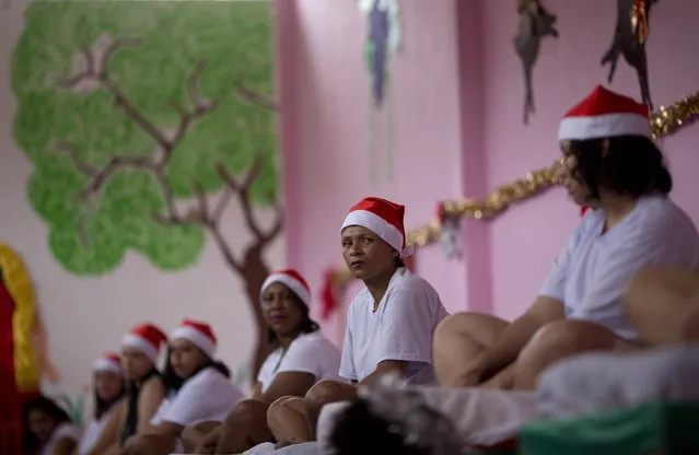 Cellmates wearing Santa caps sit on their bunks during the 8th annual Christmas event at the Nelson Hungria Prison, in Rio de Janeiro, Brazil, Tuesday, December 12, 2017. Inmates who are serving time for offenses from burglary to homicide, spent weeks decking out the cell blocks with the holiday decorations they created. The inmates used materials they had access to behind bars such as plastic bottles, paper, ground-up Styrofoam and aluminum trays. (Photo by Silvia Izquierdo/AP Photo)
