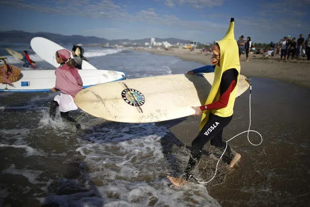 Competitors run into the Pacific Ocean during the 7th annual ZJ Boarding House Haunted Heats Halloween surf contest. (Photo by Lucy Nicholson/Reuters)