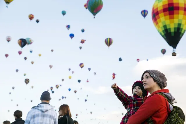 Attendees watch as hot air balloons lift off during the 2015 Albuquerque International Balloon Fiesta in Albuquerque, New Mexico, October 7, 2015. (Photo by Lucas Jackson/Reuters)