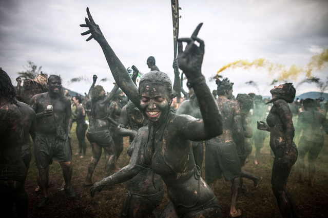 Revelers participate in the traditional Bloco da Lama (Mud block) carnival in Parati, Rio de Janeiro State, Brazil, on February 9, 2013. The event, which was begun by two men in a playful manner in 1986, has now become a traditional carnival in which participants disguised as primitives with rags, lianas or skulls and bones, dive in the mud. (Photo by Victor Moriyama/AFP Photo)