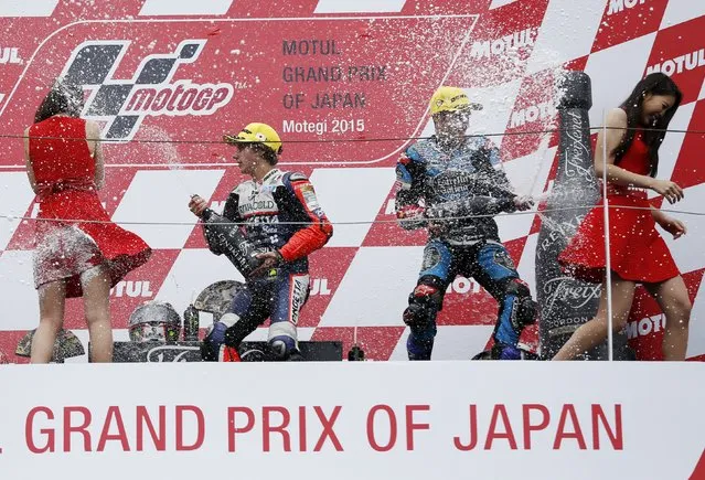 Honda Moto3 rider Niccolo Antonelli (2nd L) of Italy sprays champagne on the podium at attendants with Honda Moto3 rider Jorge Navarro (2nd R) of Spain after winning the Japanese Grand Prix at the Twin Ring Motegi circuit in Motegi, north of Tokyo, Japan, October 11, 2015. Navarro placed third. (Photo by Issei Kato/Reuters)