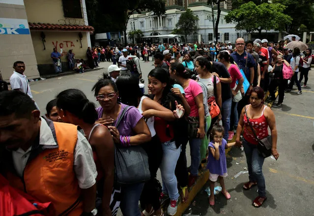 People stand in line as they wait to buy staple items and basic food outside of a supermarket in El Paraiso neighborhood in Caracas, Venezuela September 9, 2016. (Photo by Henry Romero/Reuters)