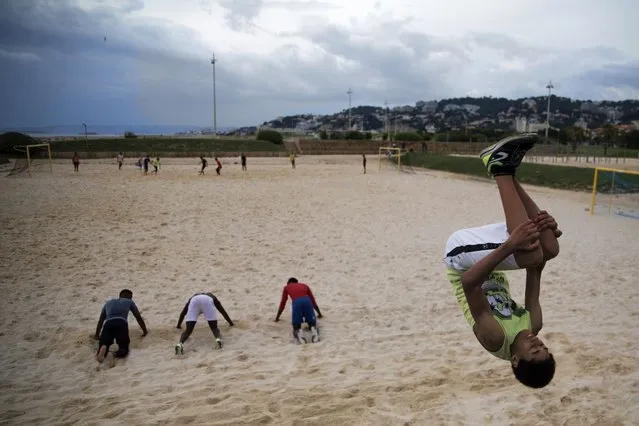 Yannis does a flip while practicing freerunning at a beach in Marseille, southern France, Saturday, May 16, 2020. Beaches in Marseille have become partially accessible since the lifting of lockdown measures meant to prevent the spread of coronavirus. (Photo by Daniel Cole/AP Photo)