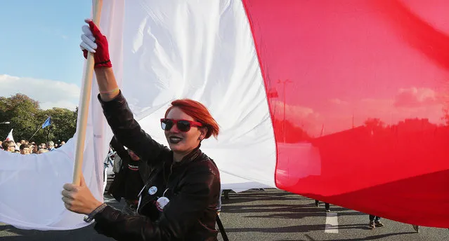 A young protestor holds a giant Polish flag during a demonstration in Warsaw, Poland, Saturday, September 24, 2016, in the latest protest against the policies of the conservative government that critics say are dividing the nation. Protesters came from many corners of Poland for the protest organized by the Committee for the Defense of Democracy, or KOD. The group has organized regular protests against the 10-month-old Law and Justice government. (Photo by Czarek Sokolowski/AP Photo)