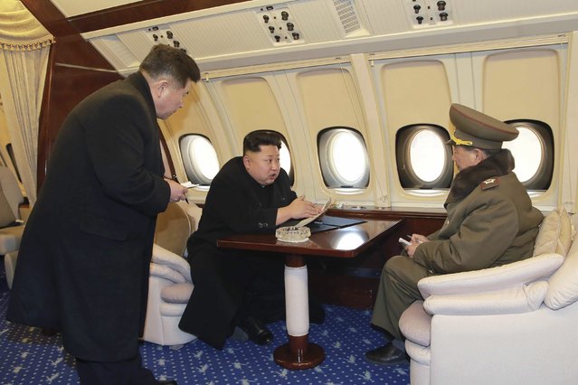North Korean leader Kim Jong Un (C) talks with officials onboard his personal plane in this undated photo released by North Korea's Korean Central News Agency (KCNA) in Pyongyang February 15, 2015. (Photo by Reuters/KCNA)
