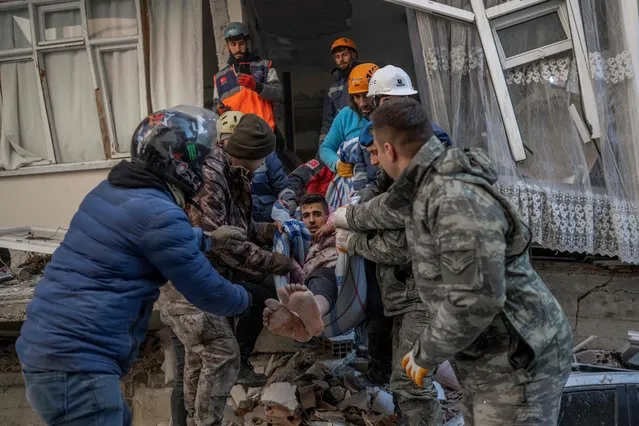 Rescuers carry a man as he is rescued after being stuck in rubble for two days in Hatay, southeastern Turkey, on February 8, 2023, two days after a strong earthquake struck the region. Searchers were still pulling survivors on February 8 from the rubble of the earthquake that killed over 11,200 people in Turkey and Syria, even as the window for rescues narrowed. For two days and nights since the 7.8 magnitude quake, thousands of searchers have worked in freezing temperatures to find those still alive under flattened buildings on either side of the border. (Photo by Bulent Kilic/AFP Photo)