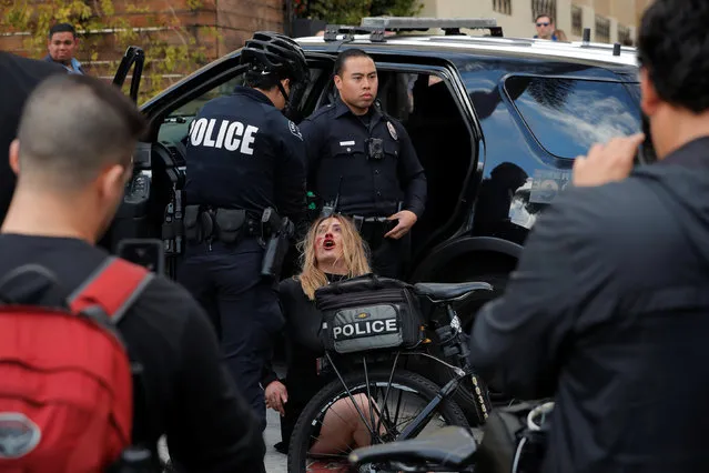 A woman with a bloody nose is detained after a scuffle by police officers outside of the Roosevelt Hotel in Hollywood, Los Angeles, California, U.S., March 3, 2018. (Photo by Lucas Jackson/Reuters)