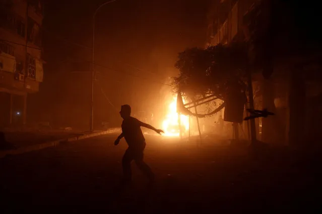 A man runs near a burning car after an airstrike in the rebel held Douma neighbourhood of Damascus, Syria October 3, 2016. (Photo by Bassam Khabieh/Reuters)