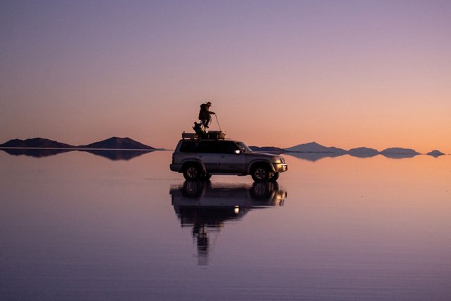 Tourists watch the sunset at the Uyuni salt flat, in Uyuni, Bolivia, 21 July 2025. The Uyuni salt flat is the largest in the world with an extension of more than 10,000 square kilometers and holds large reserves of lithium. (Photo by Esteban Biba/EPA)