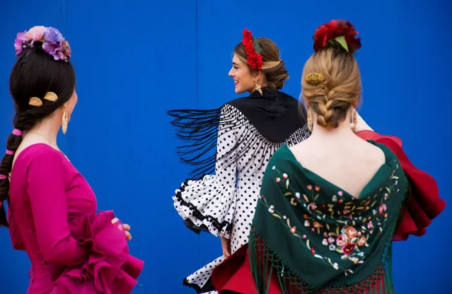 Women wearing traditional costumes chat during the first day of the April Fair celebrations in Sevilla, southern Spain, 15 April 2018. (Photo by Raúl Caro Cadenas/EPA/EFE)