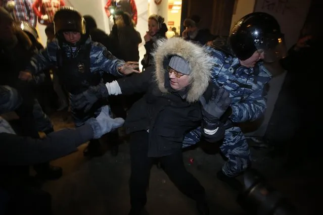 Police officers detain a protester during unsanctioned protest in Moscow, Russia, Tuesday, December 30, 2014. (Photo by Denis Tyrin/AP Photo)
