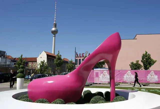 A giant shoe is pictured outside a life-size “Barbie Dreamhouse” of Mattel's Barbie dolls in Berlin, May 15, 2013. The life-sized house, covering about 1,400 square metres offers visitors to try on Barbie's clothes in her walk-in closet, tour her living room and her kitchen. (Photo by Fabrizio Bensch/Reuters)