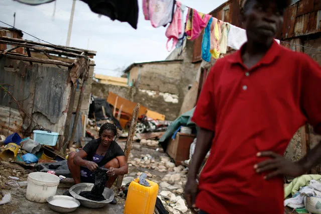 A woman washes clothes amidst the rubble of her destroyed house after Hurricane Matthew hit Jeremie, Haiti, October 19, 2016. (Photo by Carlos Garcia Rawlins/Reuters)