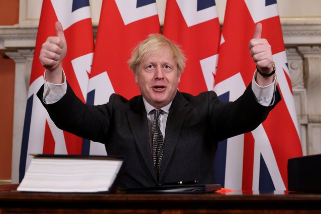 Britain's Prime Minister Boris Johnson gives a double thumbs up after signing the Trade and Cooperation Agreement between the UK and the EU, the Brexit trade deal, at 10 Downing Street in central London on December 30, 2020. British Prime Minister Boris Johnson on Wednesday signed a post-Brexit trade deal with the European Union, acclaiming it as the start of a “wonderful relationship” across the Channel “It's an excellent deal for this country but also for our friends and partners”, he said at the signing in Downing Street, after EU chiefs Ursula von der Leyen and Charles Michel earlier had themselves inked the 1,246-page Trade and Cooperation Agreement. (Photo by Crown Copyright/Pool via AFP Photo)