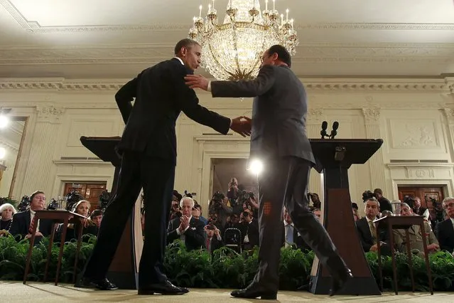 U.S. President Barack Obama (L) greets French President Francois Hollande during a joint news conference in the East Room of the White House in Washington November 24, 2015. (Photo by Carlos Barria/Reuters)