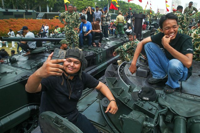 People take photos on top of an armoured personnel carrier at the 80th anniversary parade of the Indonesian national army at the National Monument Complex in Jakarta, Indonesia on October 4, 2025. (Photo by Claudio Pramana/Zuma Press Wire/Rex Features/Shutterstock)