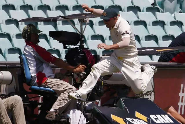 Australia's David Warner jumps to avoid running into a television camera while trying to field the ball during the fourth day's play in the fourth test against India at the Sydney Cricket Ground (SCG) January 9, 2015. (Photo by David Gray/Reuters)