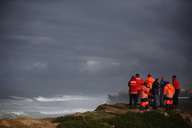 Rescue workers look at the sea as a rescue team continues its search for five missing fishermen at Macas beach, near Sintra January 14, 2015. Rescuers continued their search for the missing fishermen after their boat was shipwrecked on the beach last night, according to authorities. (Photo by Rafael Marchante/Reuters)