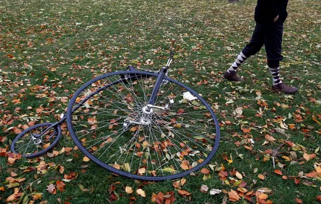 A man wearing a historical costume walks past high-wheel bicycle before the annual penny farthing race in Prague, Czech Republic November 5, 2016. (Photo by David W. Cerny/Reuters)