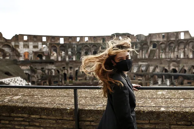 A woman visits the Rome's ancient Colosseum after its reopening Monday, February 1, 2021, in a partial lifting of restriction measures aimed at containing the spread of COVID-19. Italy has eased its coronavirus restrictions Monday for most of the country downgrading Lazio and other regions from medium-risk orange zones to lower-risk yellow zones. (Photo by Cecilia Fabiano/LaPresse via AP Photo)