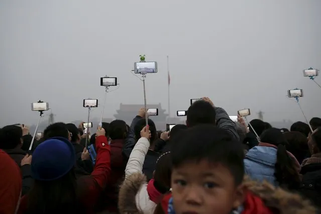 People film with their cameras during a flag-raising ceremony amid heavy smog at the Tiananmen Square, after the city issued its first ever "red alert" for air pollution, in Beijing December 9, 2015. (Photo by Damir Sagolj/Reuters)