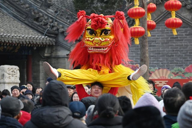 People watch lion dancers as they perform at a temple fair on the third day of the Lunar New Year of the Snake in Beijing on January 31, 2025. (Photo by Greg Baker/AFP Photo)