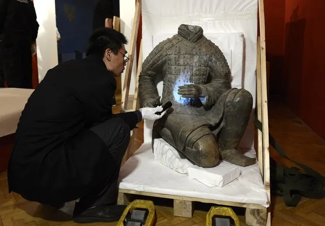 He Daxin, museologist of the Shaanxi History Museum oversees the unpacking of an ancient Chinese artwork, an original soldier statue of Emperor Qin Shi Huang's Terracotta Army, prior to the opening of the Chinese exhibition called “The Treasures of the Ancient China” in the Museum of Applied Arts in Budapest, Hungary, Thursday, January 29, 2015. The exhibition opens on Feb. 6, 2015. (Photo by Tamas Kovacs/AP Photo/MTI)