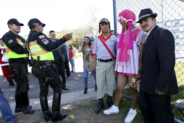 Police officers in costumes chat before participating in a Christmas event for street children in Quito December 22, 2015. (Photo by Guillermo Granja/Reuters)