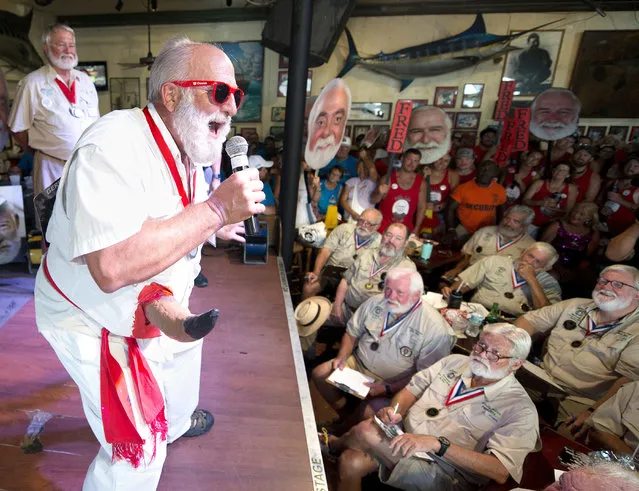 In this Saturday, July 21, 2018, photo provided by the Florida Keys News Bureau, Pat Lanier, with a fake bull horn protruding from his side, explains to the judges why he should be chosen the winner of the 2018 Hemingway Look-Alike Contest at Sloppy Joe's Bar in Key West, Fla. The highlight event of the island city's annual Hemingway Days festival attracted 151 men who vied for the coveted title. Ernest Hemingway lived and wrote in Key West during much of the 1930s. One of Hemingway's most famous books was about the art of bullfighting. (Photo by Andy Newman/Florida Keys News Bureau via AP Photo)