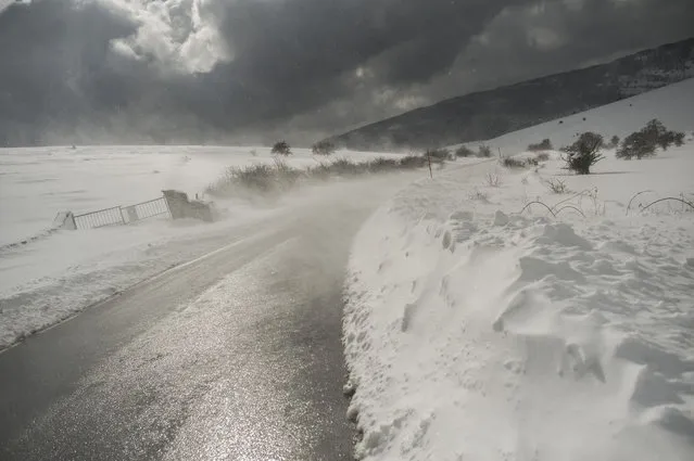 The wind blows snow on a road, in Lizarraga northern Spain, Wednesday, February 4, 2015. A cold spell has reached northern Spain with temperatures plummeting far below zero. (Photo by Alvaro Barrientos/AP Photo)