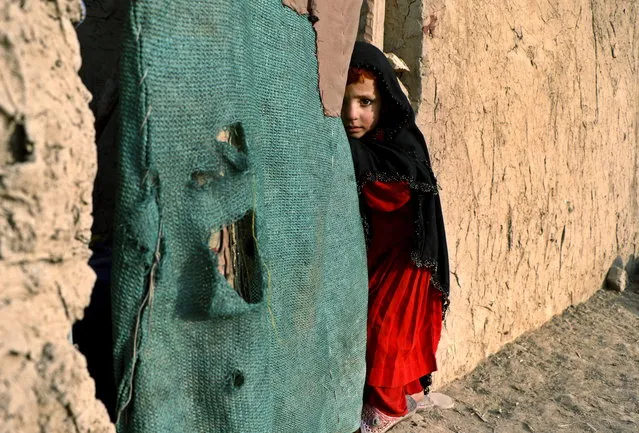 A young Afghan Internally Displaced Person (IDP) stands outside a temporary shelter in an IDP camp in Kabul, Afghanistan, December 21, 2015. According to UN Refugee Agency (UNHCR) figures, the number of internally displaced Afghans was 683,000 by mid-2014, a number expected to climb to 900,000 by the end of 2015, as unrest continues in the country after several offensives by the Taliban in various provinces leading to large Afghan National Army (ANA) losses. (Photo by Hedaytullah Amid/EPA)